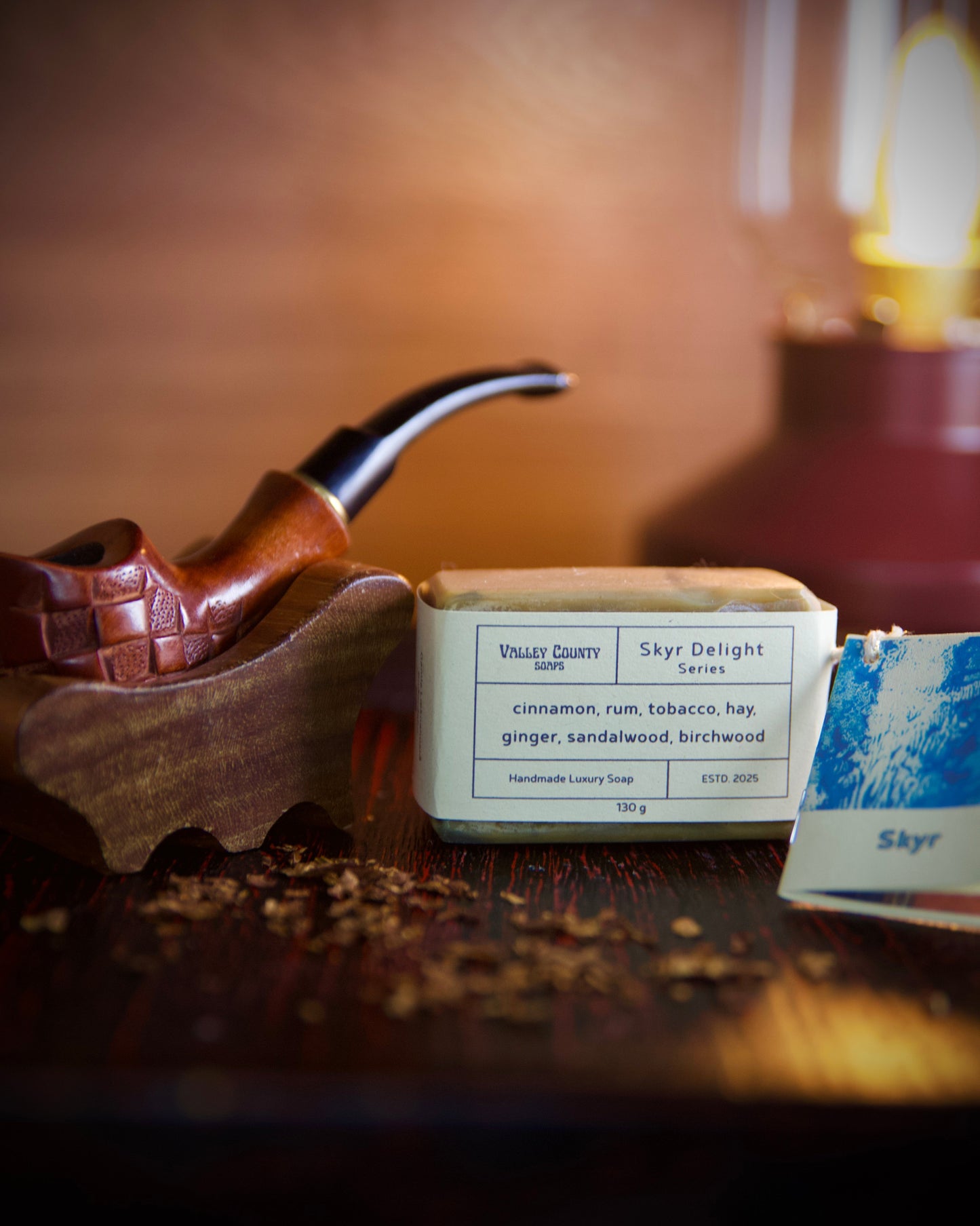 Wooden pipe and tobacco container and soap on a wooden surface with a blurred background