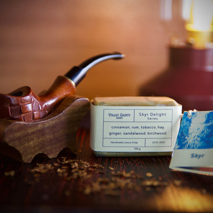 Wooden pipe and tobacco container and soap on a wooden surface with a blurred background