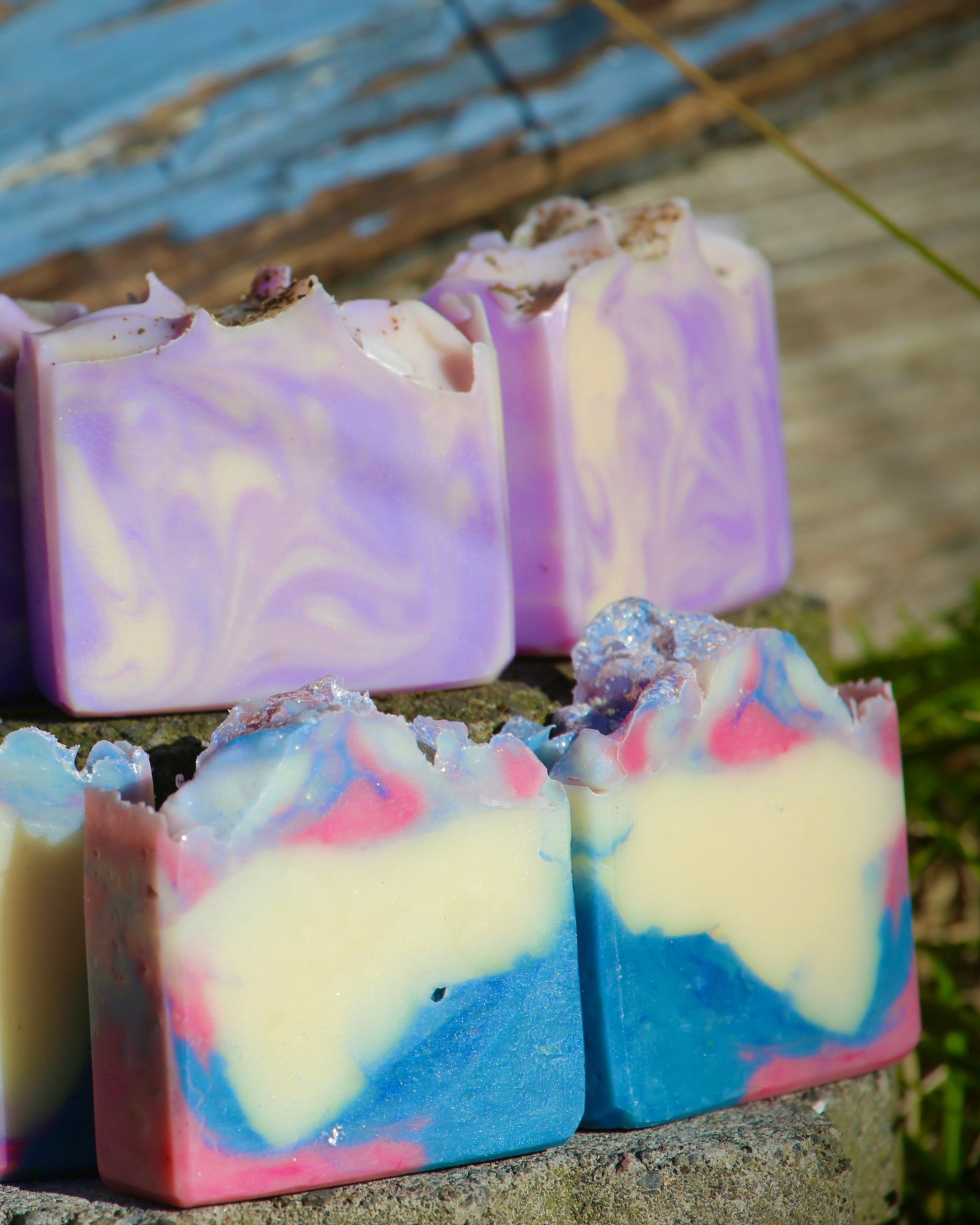 Colorful soap bars with a marbled pattern on a stone surface. Rustic background.