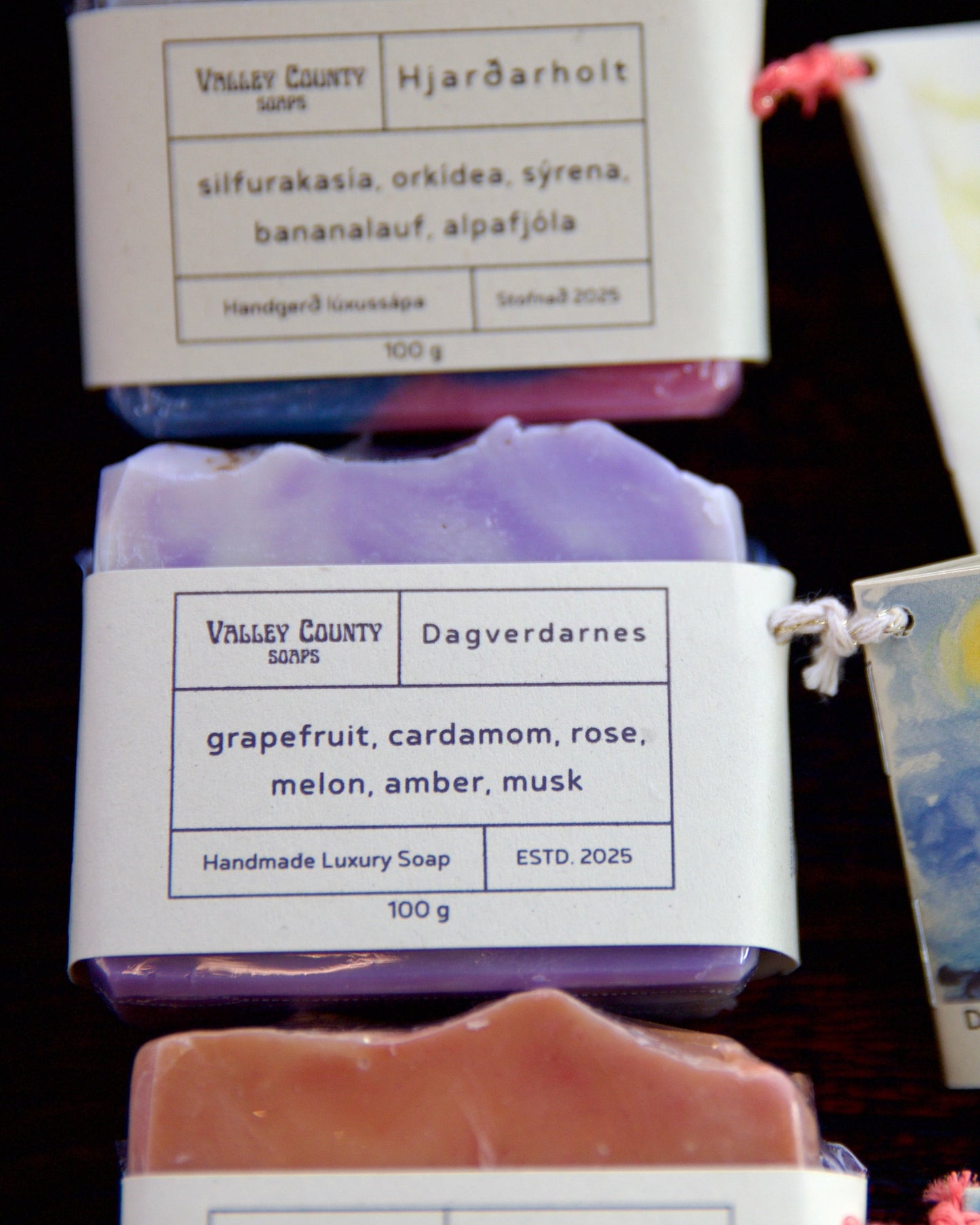 Handmade soap bars with labels on a dark background