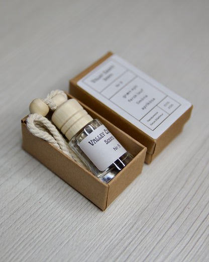 Small glass bottle with a wooden cap in a elegant box on a light gray surface